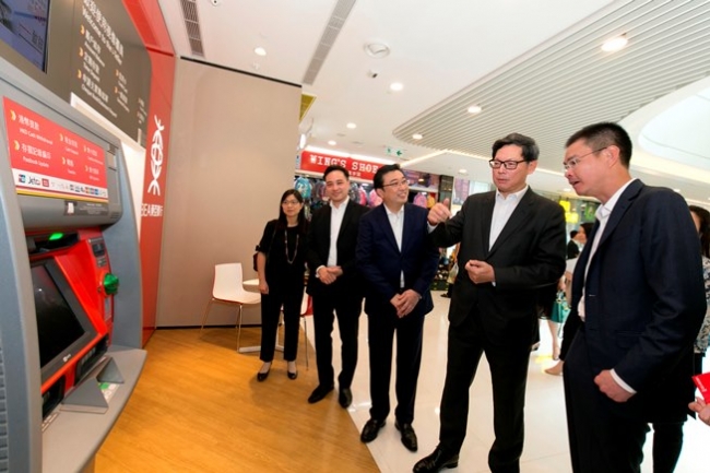 东亚银行副行政总裁李民桥先生及银行代表向金管局总裁陈德霖先生介绍无卡自动柜员机提款服务。